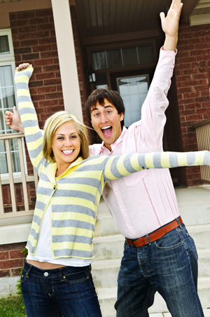 Excited couple in front of new home